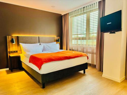 1 dormitorio con 1 cama y TV en Trip Inn Hotel Frankfurt-Heusenstamm, en Heusenstamm