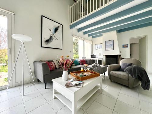 a living room with a couch and a table at Villa de la Cible in Saint-Martin-de-Ré