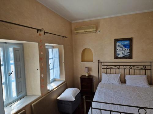 a bedroom with a bed and two windows at Nasur in Éxo Goniá