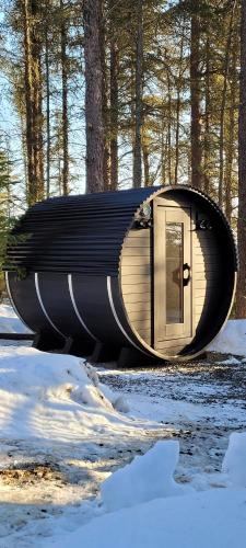 a cylindrical building with a door in the woods at Charlevoix expérience thermale en pleine nature - Suites Nature Charlevoix - Suite #1 in Les Éboulements
