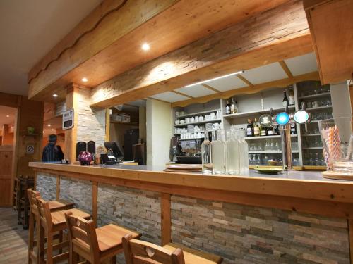 a bar in a restaurant with wooden beams at Auberge Le Tétras Lyre in Vassieux-en-Vercors