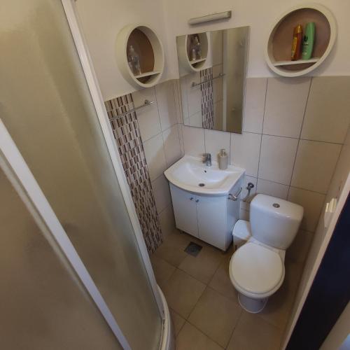 a small bathroom with a toilet and a sink at Studio apartment with sea view in Sali