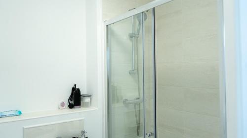 a shower with a glass door in a bathroom at 1BR Sleeps 4, 3 mins from City centre & Local Gems in Burton upon Trent