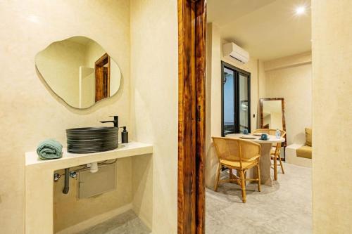 y baño con lavabo, espejo y mesa. en Suite luxe avec Jacuzzi privé, en Marrakech