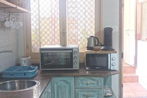 a kitchen with a microwave and a toaster oven on a counter at Maison de charme 2 terrasses, en ville, mer, port. in Águilas