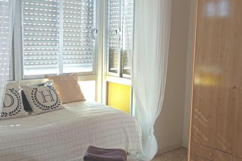 a bedroom with a bed with pillows and a window at Maison de charme 2 terrasses, en ville, mer, port. in Águilas