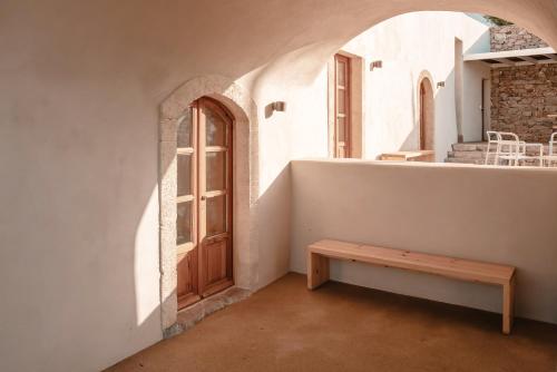 a room with a wooden door and a bench at Casa Kombonada in Kýthira