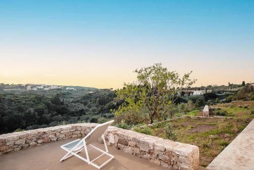 a white chair sitting on top of a stone wall at Casa Kombonada in Kýthira