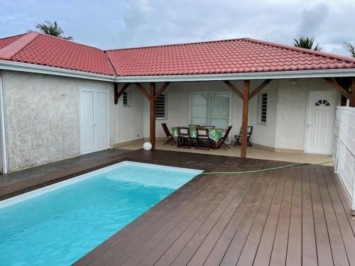 une maison avec une piscine et un toit rouge dans l'établissement Villa Fusains, à Baie-Mahault