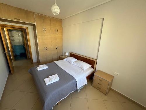 a bedroom with a bed with two towels on it at Comfort 1 Apartment in Sarandë