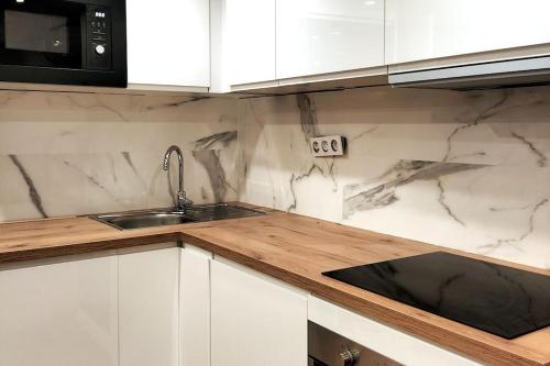 une cuisine blanche avec un évier et un micro-ondes dans l'établissement Studio au coeur du vieux Nice, à Nice