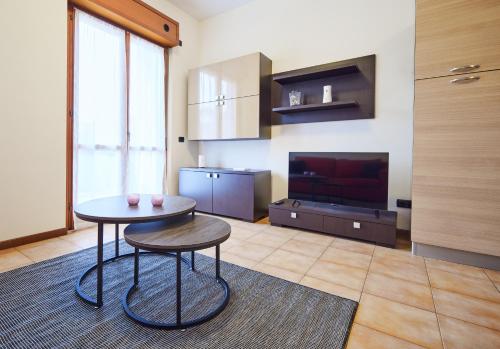 een woonkamer met een tafel en een televisie bij Residenza Il Centro in Brivio