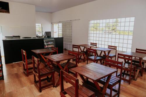 a dining room with wooden tables and chairs at Ribas Pousada e Camping in Carambeí