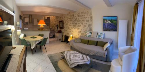 ein Wohnzimmer mit einem Sofa und einem Tisch in der Unterkunft LE MAS D'ISACHRIS Le T2 in La Garde-Adhémar