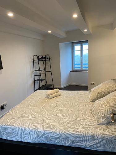 a bedroom with a bed with two towels on it at L’échappée belle, vue panoramique sur la campagne in Saint-Saturnin-de-Lenne