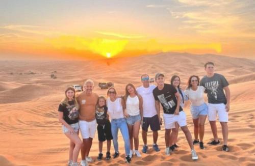 a group of people posing for a picture in the desert at Merzouga Luxurious Camp in Merzouga