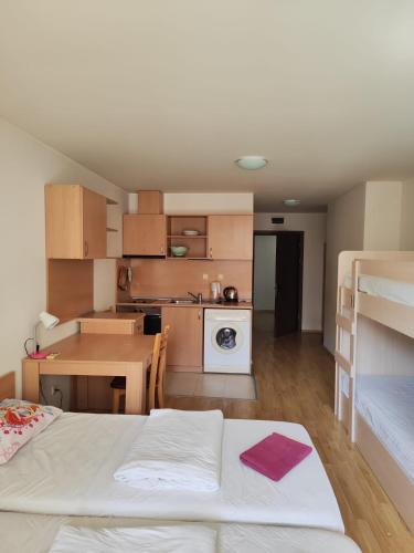 a room with a bed and a table and a kitchen at Julia Vigo Panorama apartments in Nesebar