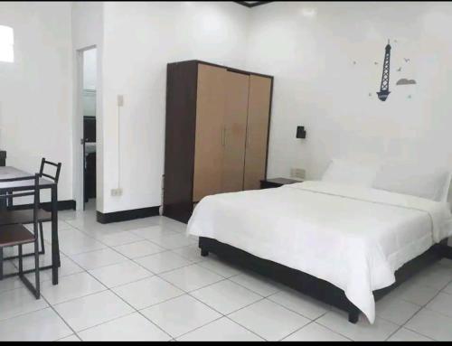 1 dormitorio con cama, mesa y escritorio en Ethan's Vacation House (Camiguin), en Mambajao