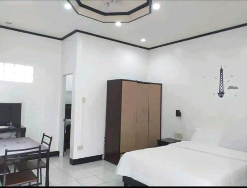 um quarto com uma cama, uma secretária e um armário em Ethan's Vacation House (Camiguin) em Mambajao