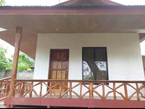a house with two doors and a balcony at Ethan's Vacation House (Camiguin) in Mambajao