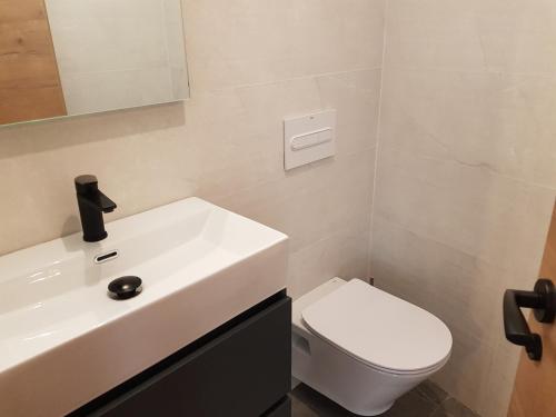 a bathroom with a white sink and a toilet at Pis clar i espaiós in Manresa