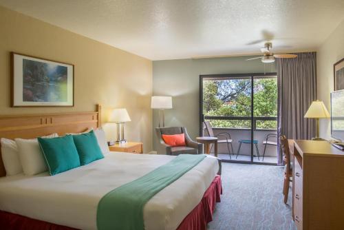 a hotel room with a bed and a large window at Colton Inn in Monterey