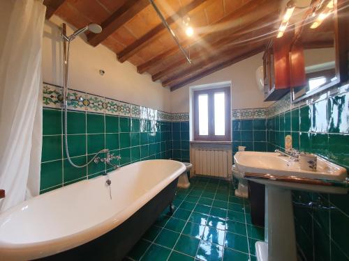 un bagno verde con vasca e lavandino di Villa Lisabetta a Montecchio
