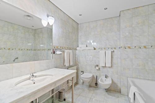 ein Bad mit einem Waschbecken und einem WC in der Unterkunft Hotel Schild in Wien