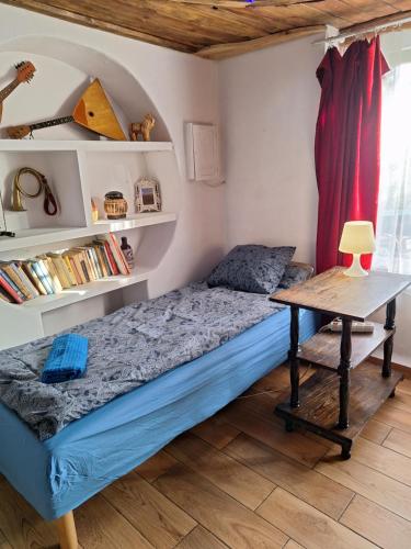 a small bedroom with a bed and a table at Szalupa Hostel Airport in Zakroczym