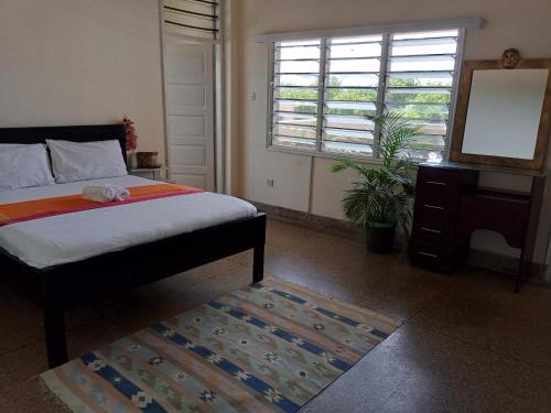 a bedroom with a bed and a table and a mirror at Samia House in Malindi