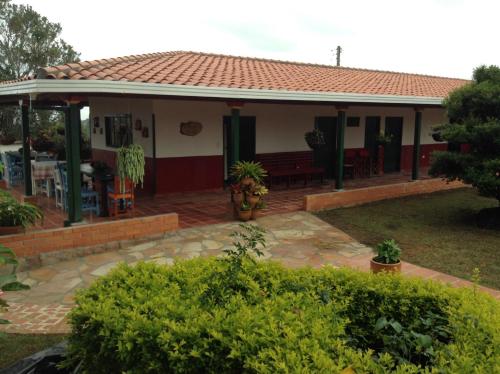 a house with a red roof and a patio at Villa Liliana Lodge Mesa de los Santos in Los Santos