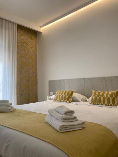 a hotel room with two beds with towels on the bed at Strettomare-Business & travel apartment in Reggio Calabria