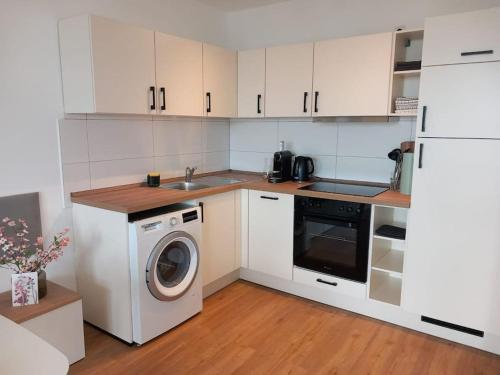 - une cuisine avec des placards blancs et un lave-linge dans l'établissement La Dolce Casa bei Hamburg, à Seevetal