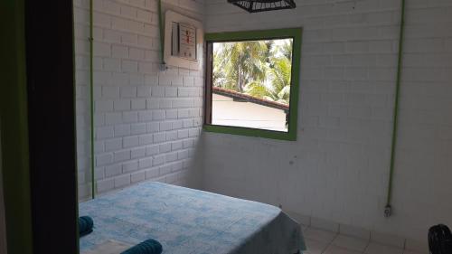 Zimmer mit einem Bett und einem Fenster in der Unterkunft Chalé Pé na Areia, Cond. Beira Mar, Maragogí/AL in Maragogi