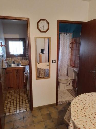 a bathroom with a sink and a toilet and a clock at Studio entre montagne et mer in Cambo-les-Bains