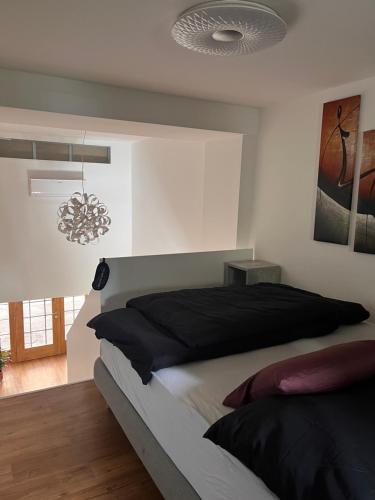 a bedroom with a large bed and a chandelier at LiLan apartment in Maribor