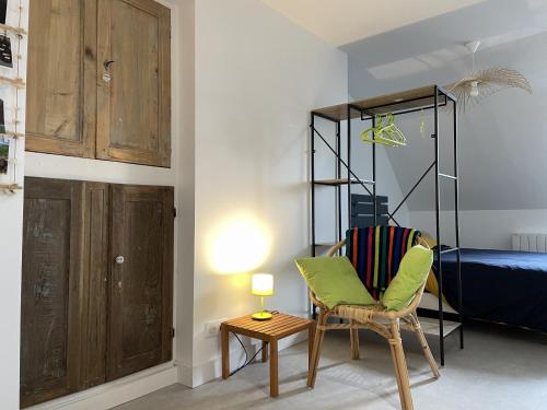 a room with a chair and a bed and a lamp at L appart d Helene, Rodez Hyper Centre in Rodez
