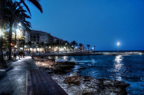a beach with palm trees and a river at night at Parque De Las Naciones Europa II in Torrevieja