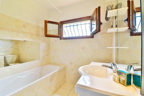 une salle de bain avec une baignoire et un lavabo et une baignoire dans l'établissement Locations-06 La maison de Noéie rdj pour 6 personnes entre mer et montagne, à Le Bar-sur-Loup