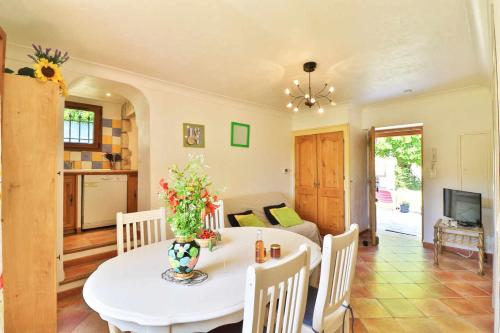 une salle à manger avec une table et des chaises blanches dans l'établissement Locations-06 La maison de Noéie rdj pour 6 personnes entre mer et montagne, à Le Bar-sur-Loup