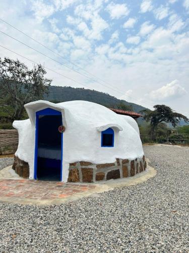 a iguana house with a blue door on a gravel road at Bahareque glamping in Barichara