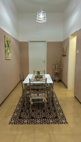 Un comedor con una mesa y sillas sobre una alfombra. en Cristina's House, en Sciacca