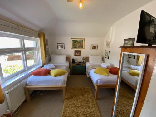 a room with three beds and a tv in it at Bosta B&B in Inverness