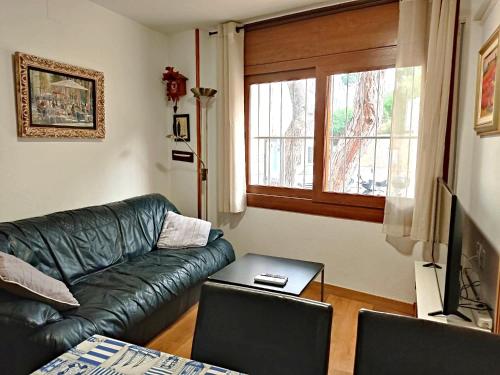 een woonkamer met een groene leren bank en een tafel bij Voramar D- Estudi in Calella de Palafrugell