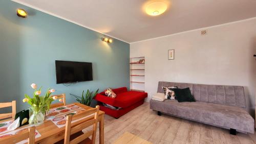 a living room with a couch and a red chair at Apartament "Przy Jeziorku" in Kętrzyn