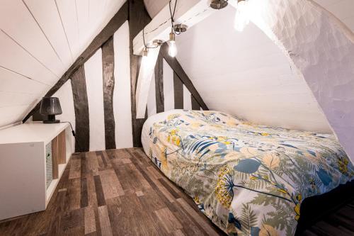 une chambre avec un lit dans un grenier dans l'établissement La Luciole, à Honfleur