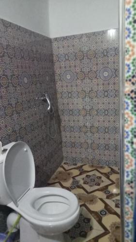 a bathroom with a toilet and a tile floor at Gîte Forest Tagroumte in Azrou