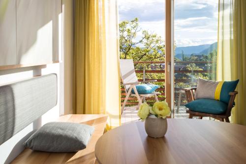a living room with a table and a balcony at Hotel Heubad in Fiè