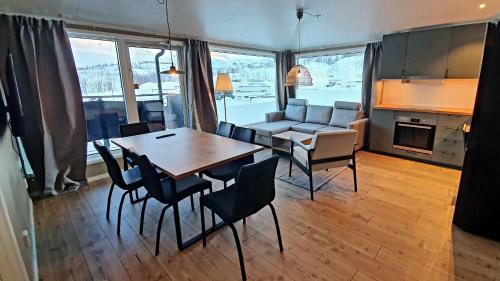 a living room with a table and chairs and a couch at Katterjåkk Apartments in Riksgränsen