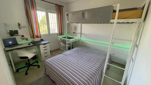 a small bedroom with a bunk bed and a desk at Calanuza in El Campello